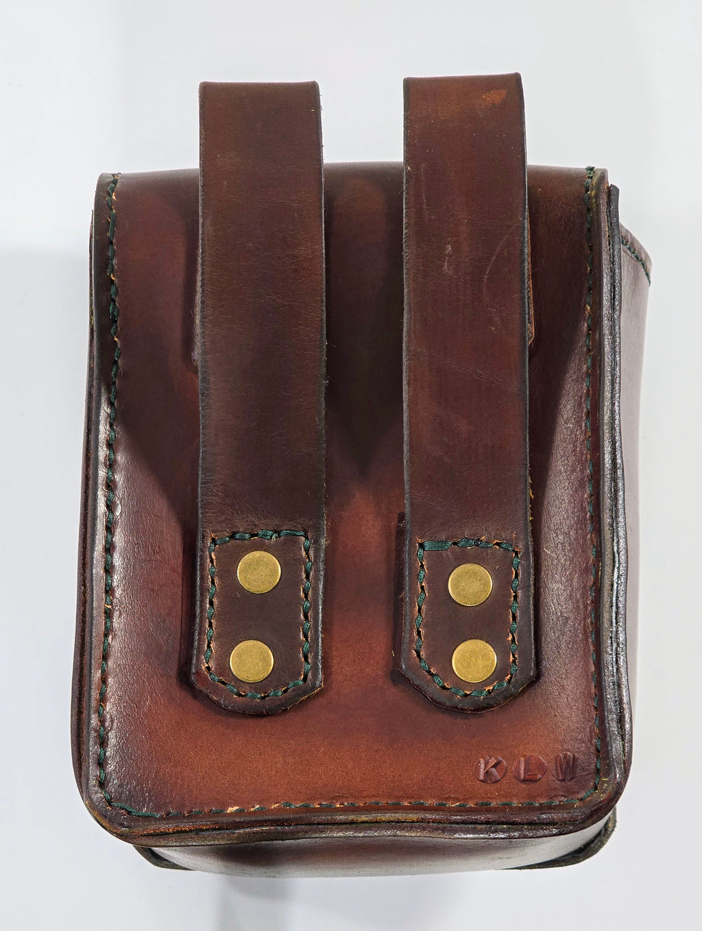 Brown leather pouch with gold rivets on a white background