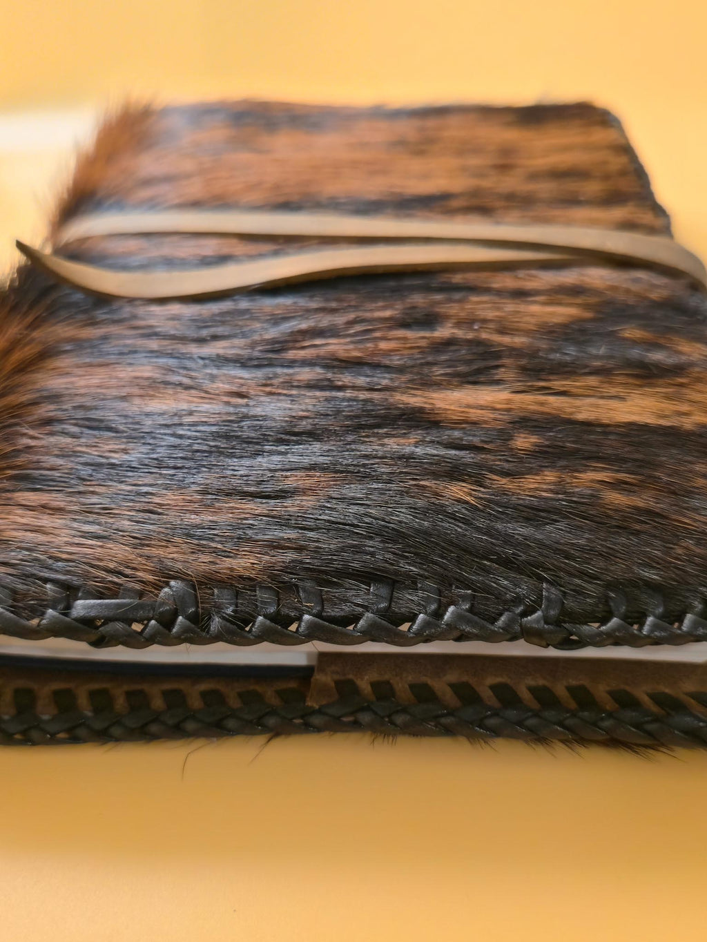 Side view of Hair on leather journal cover - Luxury handmade leather notebook protector with a yellow background