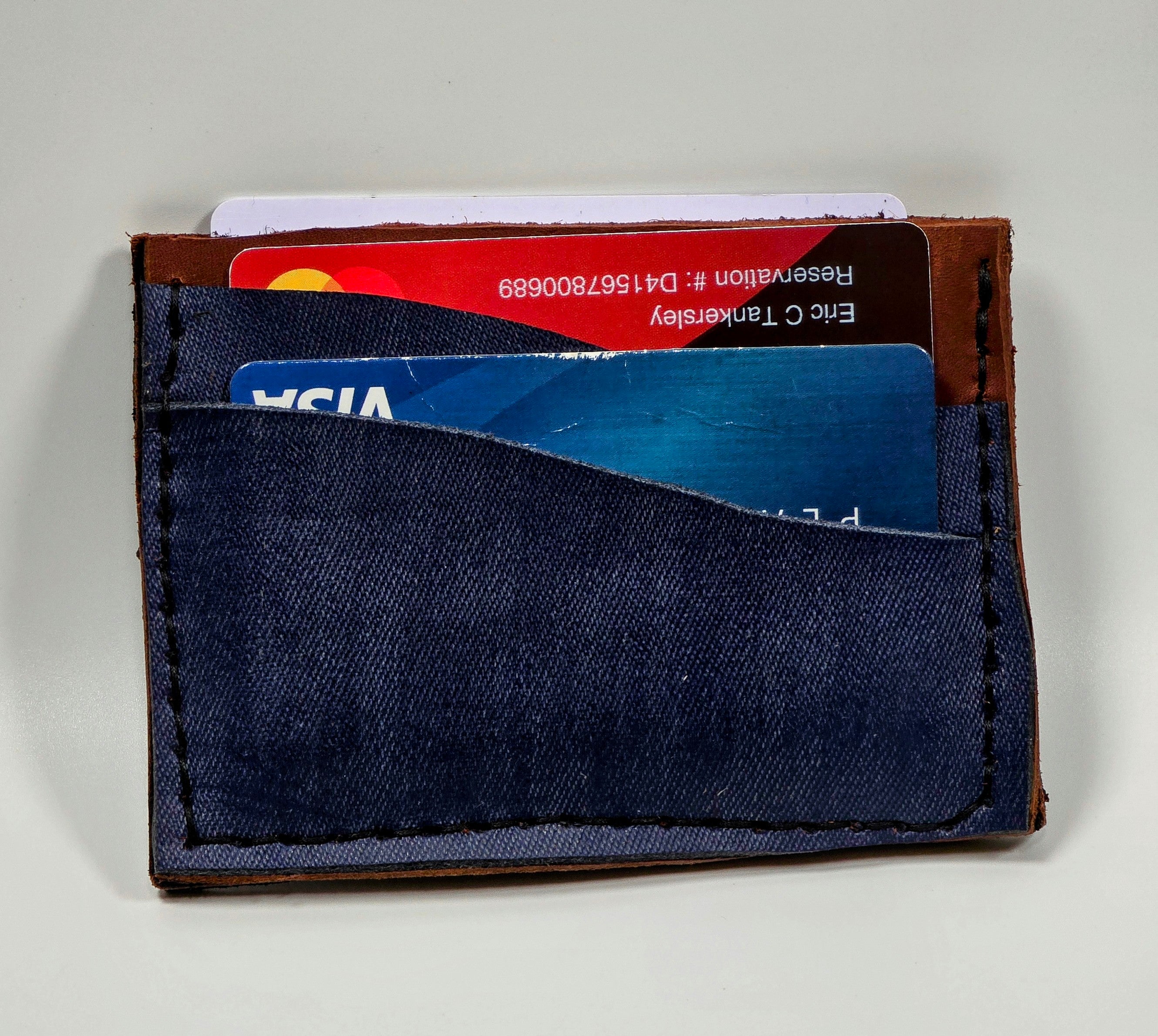 Navy blue cardholder with two cards on a light gray background