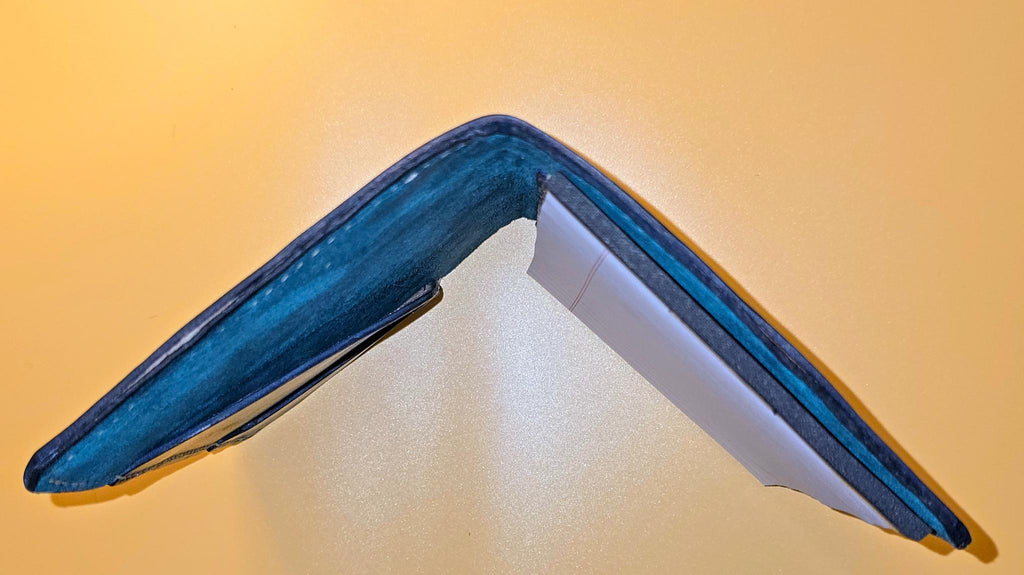 End view of open Hand-dyed leather mini padfolio with a unique, rich finish standing on a yellow background