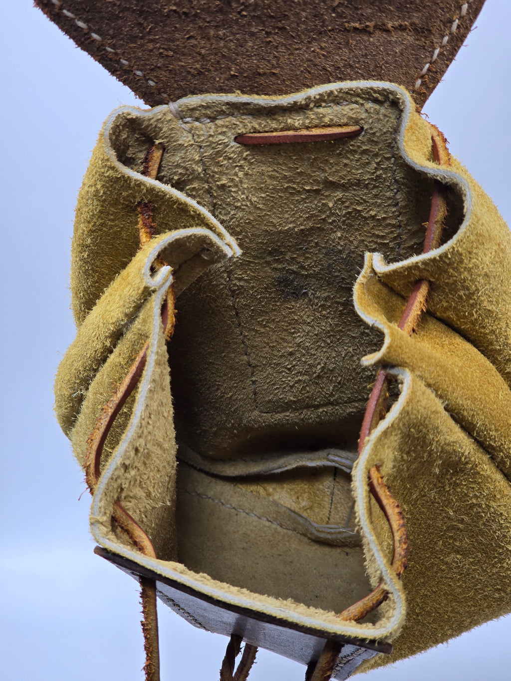 Close-up of inside of buffalo belt pouch on a light blue background