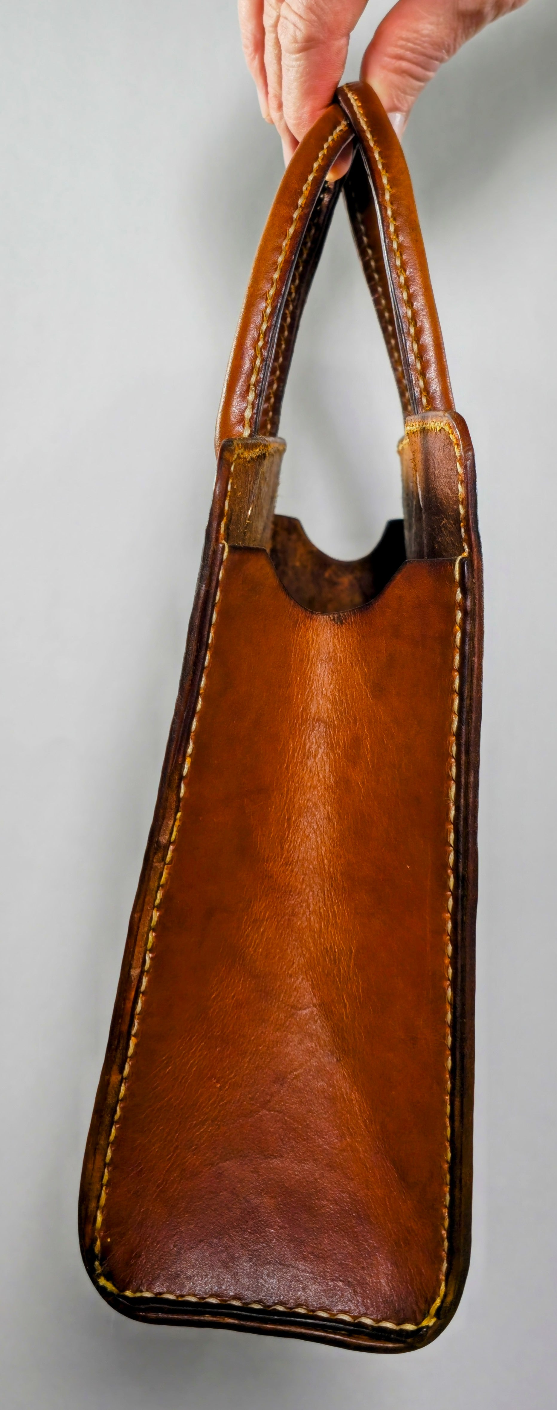 Hand-stitched vintage style leather book tote in rich brown veg tan leather, showing durable handles and clean stitching