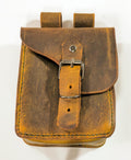 Handcrafted brown leather belt pouch with buckle closure on white background