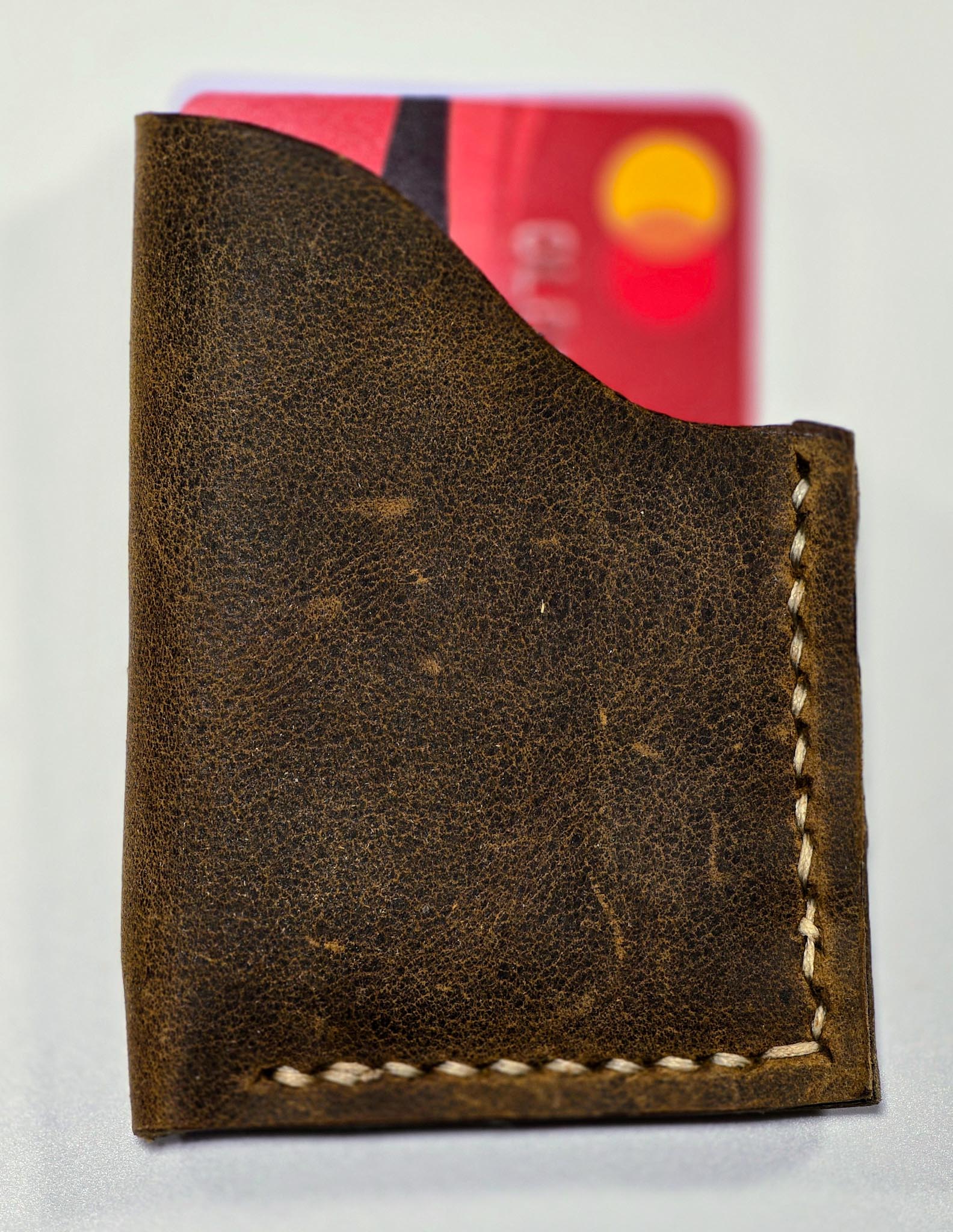 Brown leather wallet with a visible brand logo on a white background