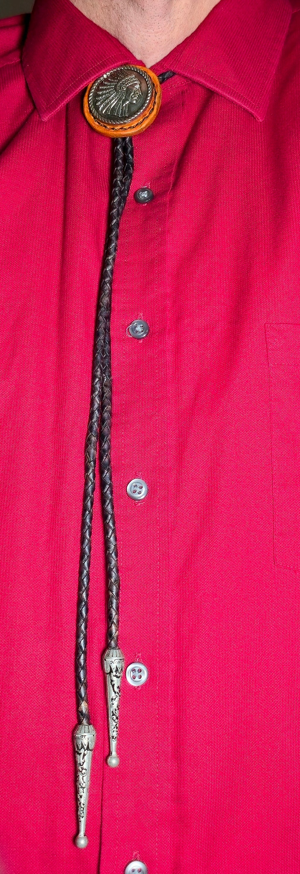 Close-up of a red shirt with a decorative bolo tie.