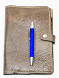 Brown embossed leather mini padfolio with a blue pen on a white background