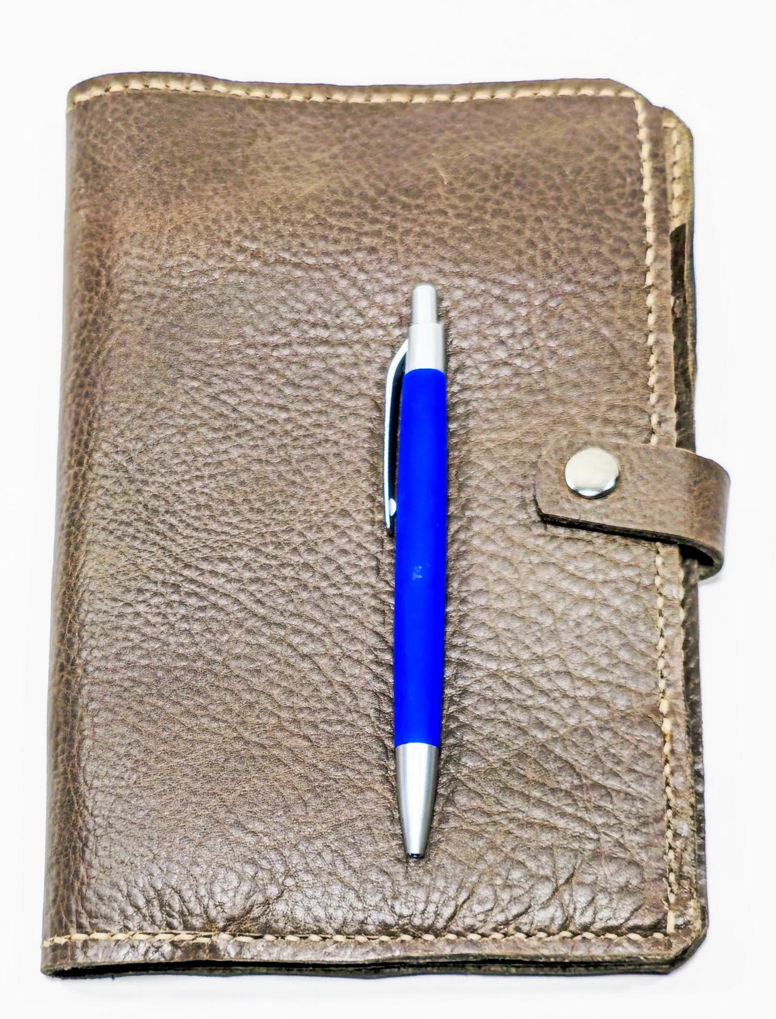 Brown leather notebook with a blue pen on a white background
