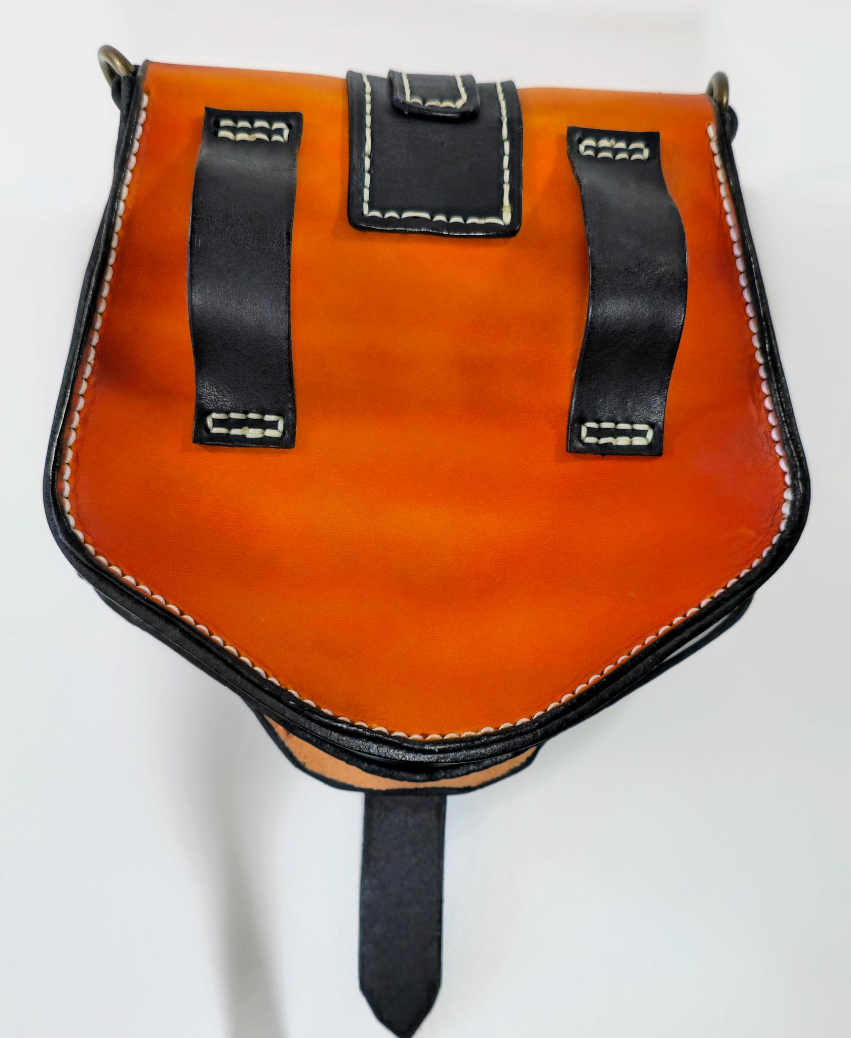 Tan and black leather pouch with black straps and stitching on a white background